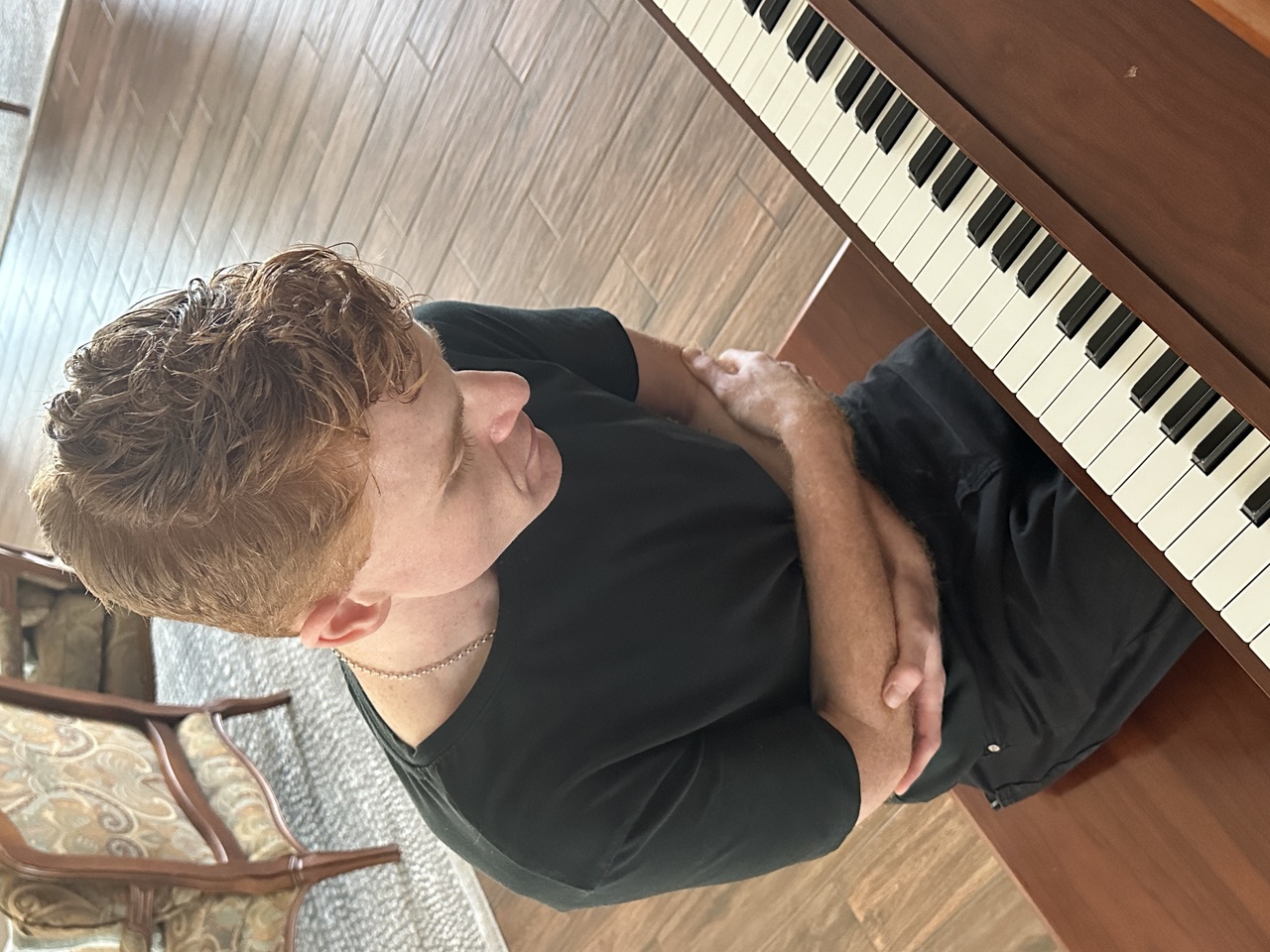 Actor Weston Allen Kemp seated at a piano during rehearsal for Nocturne at The Off-Central Players