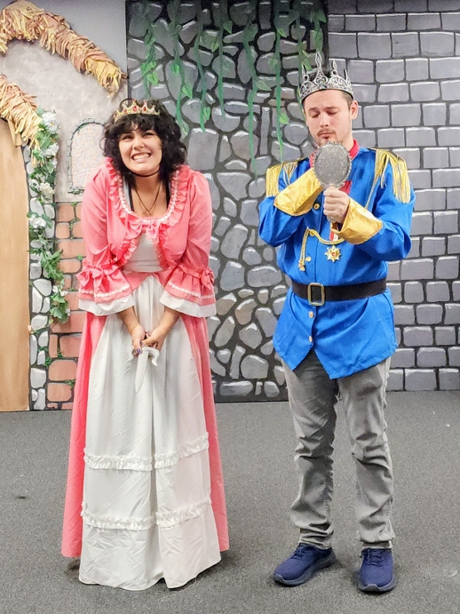 A princess and a prince holding a hand mirror in a castle set.