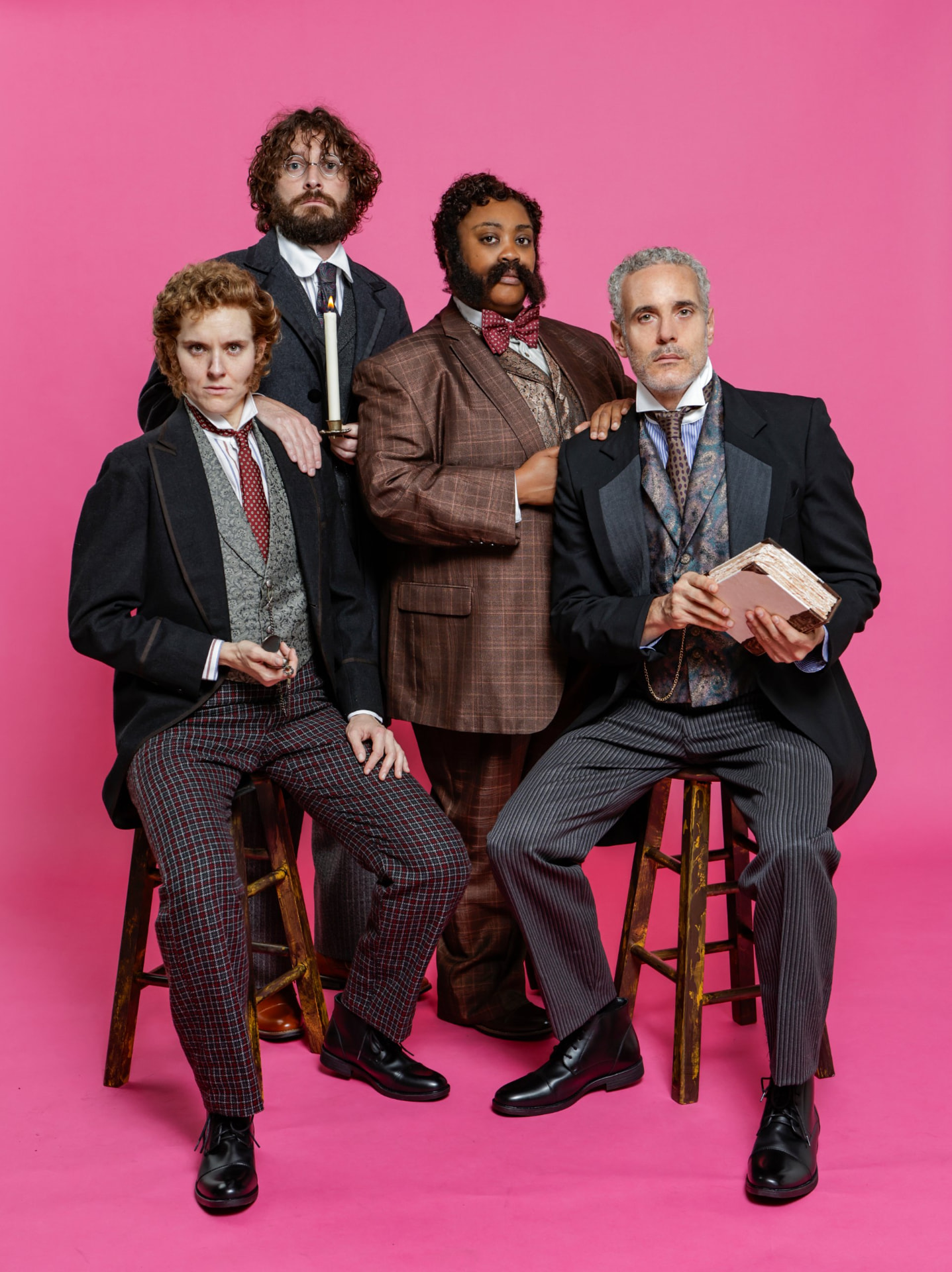 The four Ahoy-Hoy cast members pose against a pink backdrop, two seated on stools and two standing behind them.