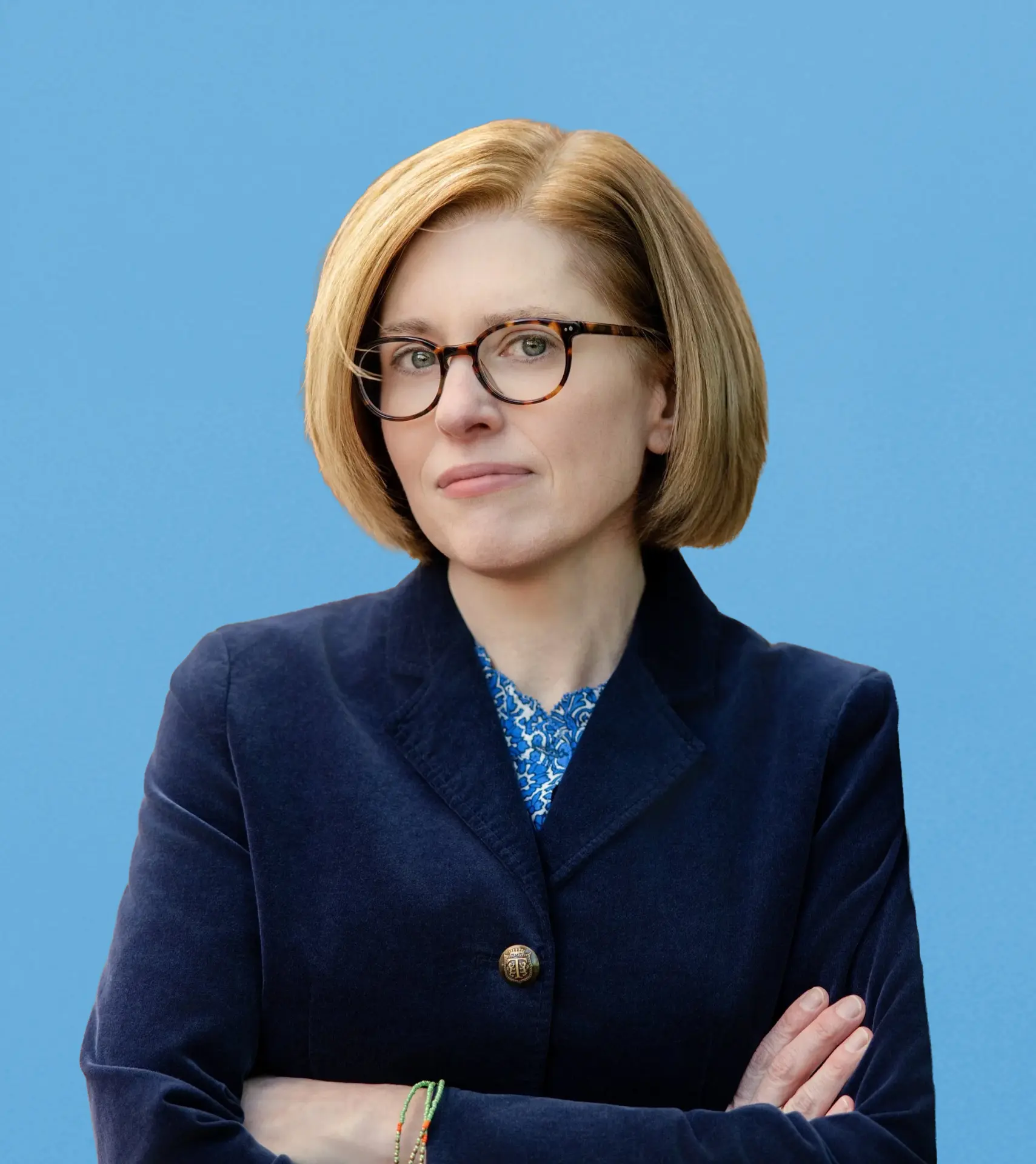 Playwright Stacey Isom Campbell, arms crossed, against a blue backdrop